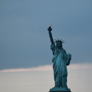 The statue of liberty with a dark, cloudy sky in the background.